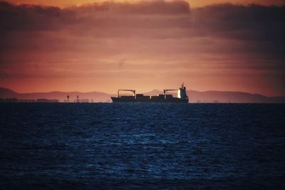 Ship in sea against sky during sunset