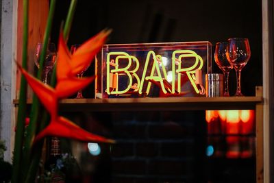 Close-up of illuminated text on glass at night