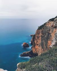 Rocks by sea against sky
