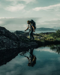 Full length of man jumping on mountain against sky