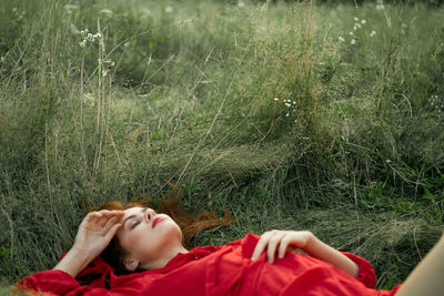 Woman lying on grassy field
