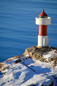 Lighthouse by sea during winter
