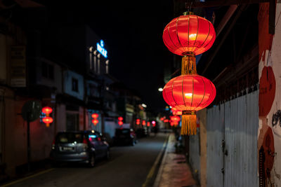 Illuminated road amidst buildings in city at night