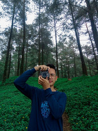 Man photographing in forest