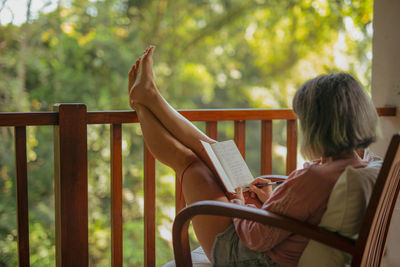 Rear view of woman reading book