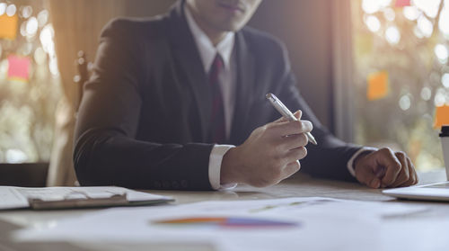 Midsection of businessman working at desk