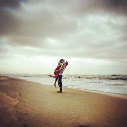 Full length of man standing on beach against sky