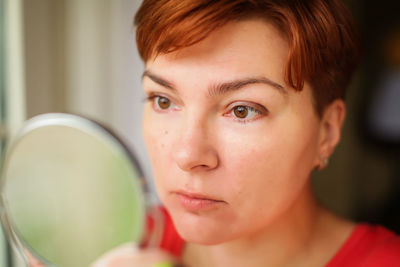 Close-up of woman looking in mirror