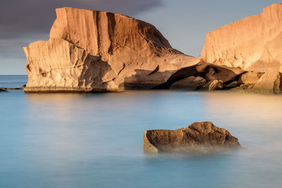 View of rock formation in sea against sky