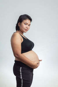 Side view of a young woman against white background