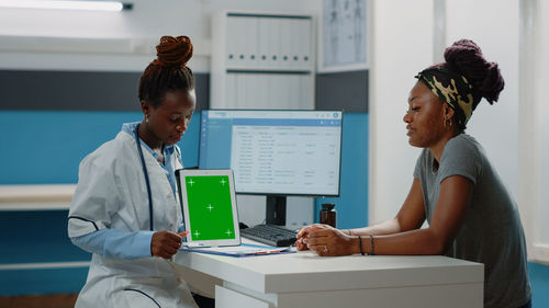 Doctor showing digital tablet to patient