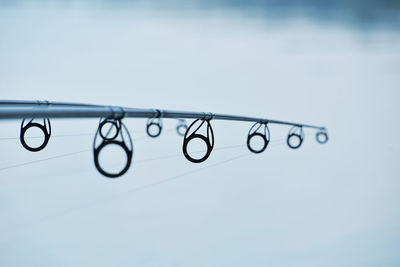 Close-up of fishing rods over lake