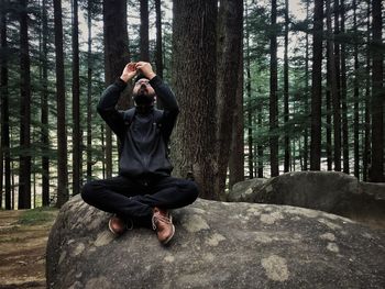 Full length of man photographing while sitting on land