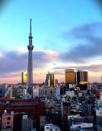 View of cityscape against cloudy sky