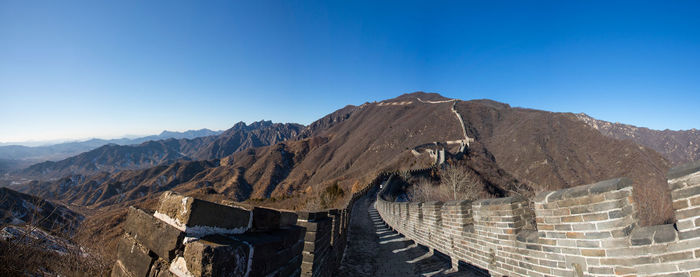 Panoramic view of mountain range against blue sky