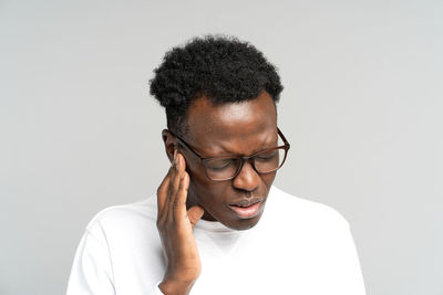 Portrait of young man wearing eyeglasses against white background