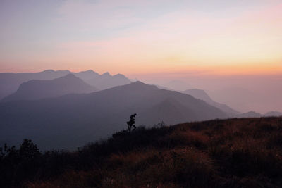 Scenic view of silhouette mountains against sky at sunset