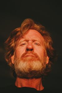 Close-up portrait of man against black background