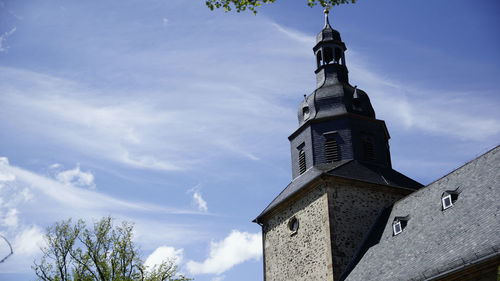 Low angle view of cross on building against sky