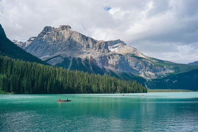 Scenic view of lake by mountains against sky