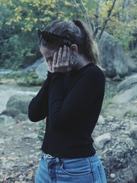 Midsection of woman standing in forest