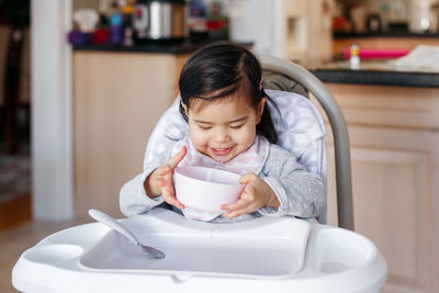 Cute girl eating food at home