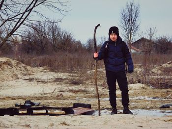 Full length portrait of man standing on street during winter