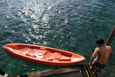 Rear view of shirtless man in sea