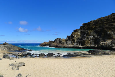 Scenic view of beach against blue sky