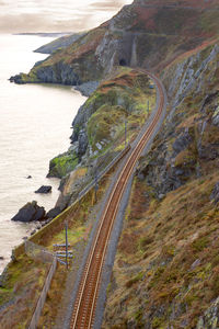 High angle view of railroad track by sea and mountain