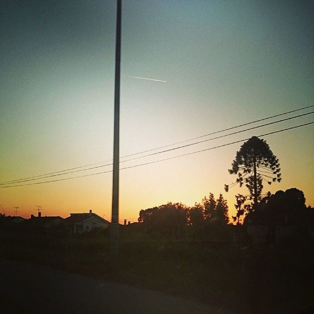 sunset, silhouette, power line, electricity pylon, copy space, tree, electricity, orange color, sky, clear sky, built structure, low angle view, cable, power supply, architecture, connection, building exterior, nature, dusk, tranquility