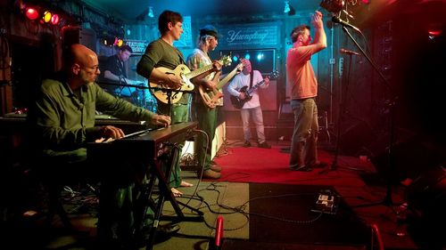 People playing guitar at music concert