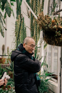 Man standing by plants against trees