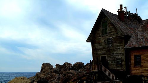 Low angle view of building by sea against sky