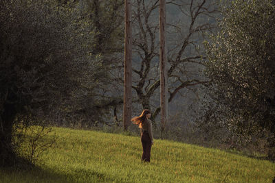 Rear view of woman walking on field