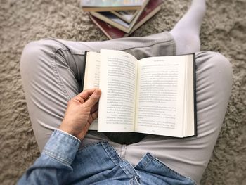 Midsection of man reading book