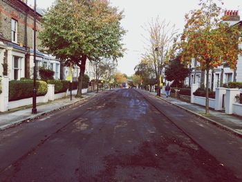 Empty road along buildings