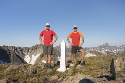 People standing on rock against sky