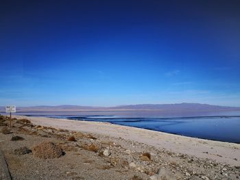 Scenic view of beach against blue sky