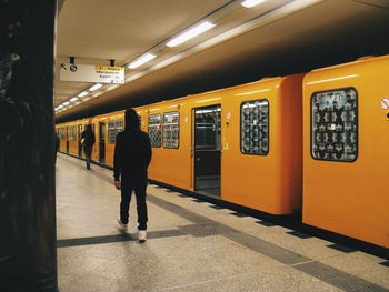 Rear view of person walking at railroad station platform