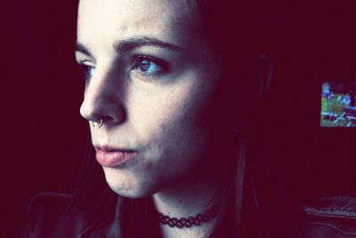 Thoughtful woman wearing choker looking away at home