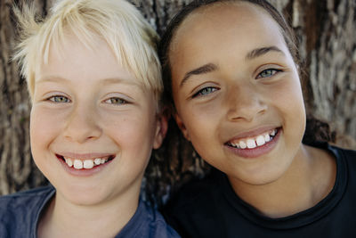 Portrait of smiling blond boy with female friend at summer camp