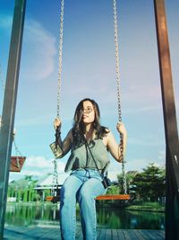 Woman sitting on swing in playground