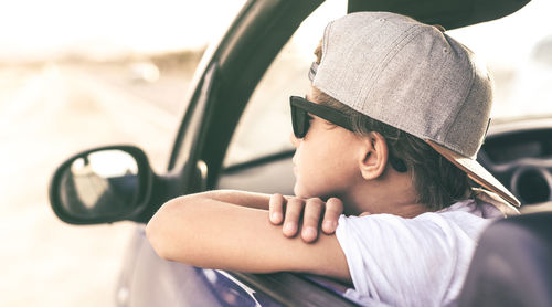 Boy looking in the car's mirror. teen with sunglasses. youth, travel, positive, freedom concept.