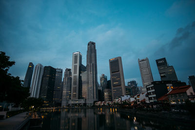 Modern buildings in city against sky at dusk