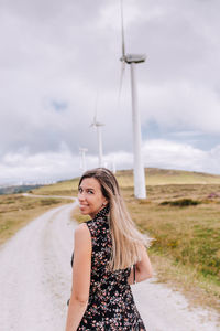 Beautiful woman standing on land against sky