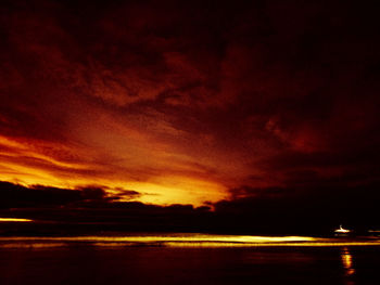 Scenic view of sea against dramatic sky during sunset