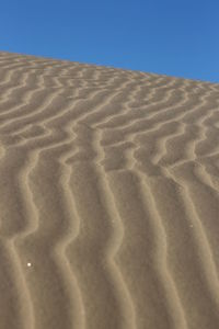 Sand dunes in desert against clear sky