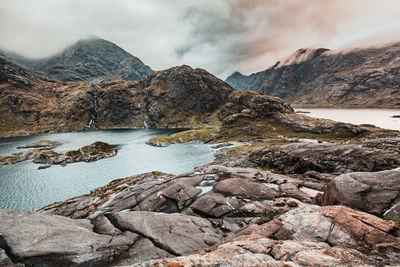 Rocks in lake against mountains