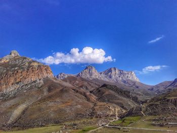 Scenic view of mountains against blue sky